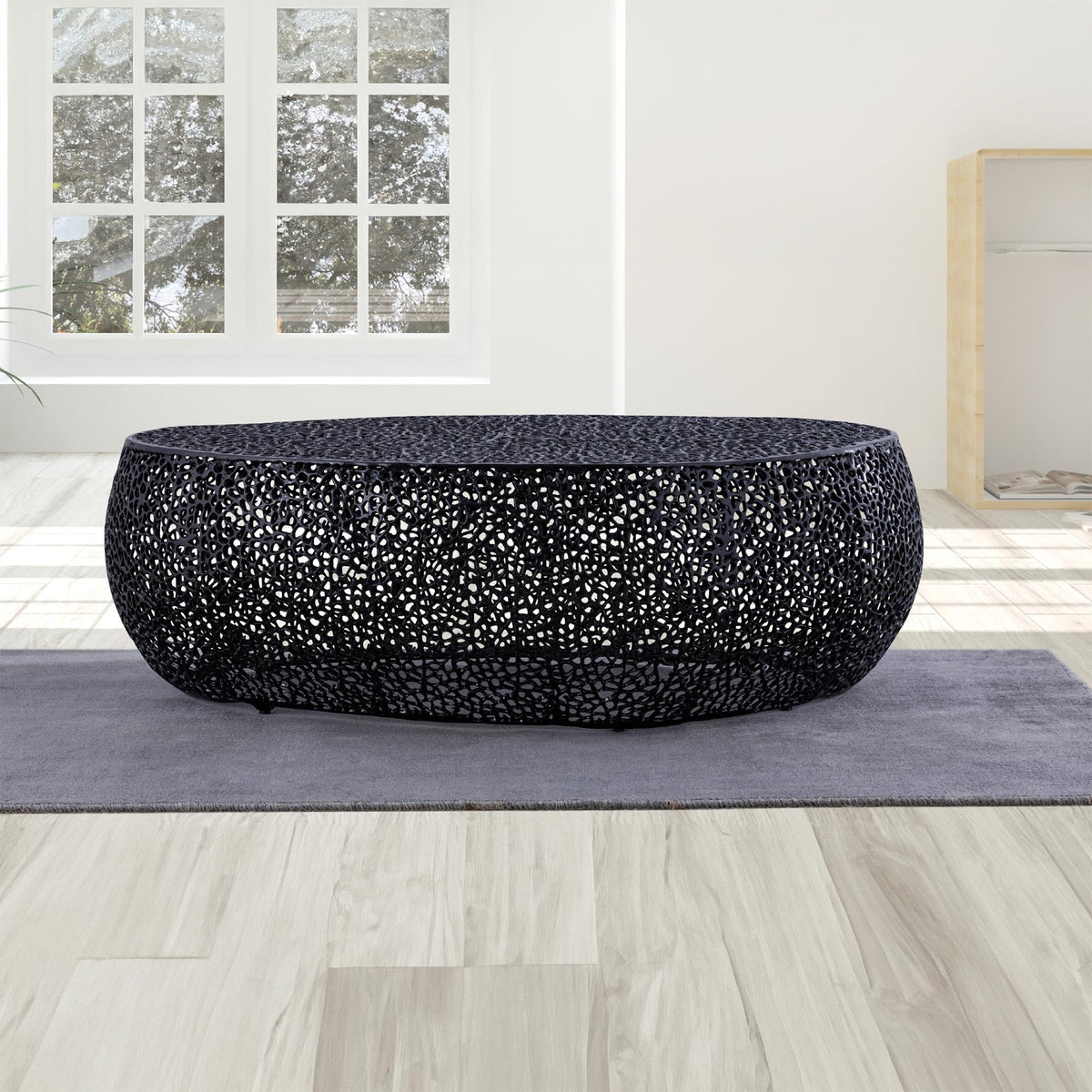 T3601 Black oval coffee table with an openwork surface in a bright room.